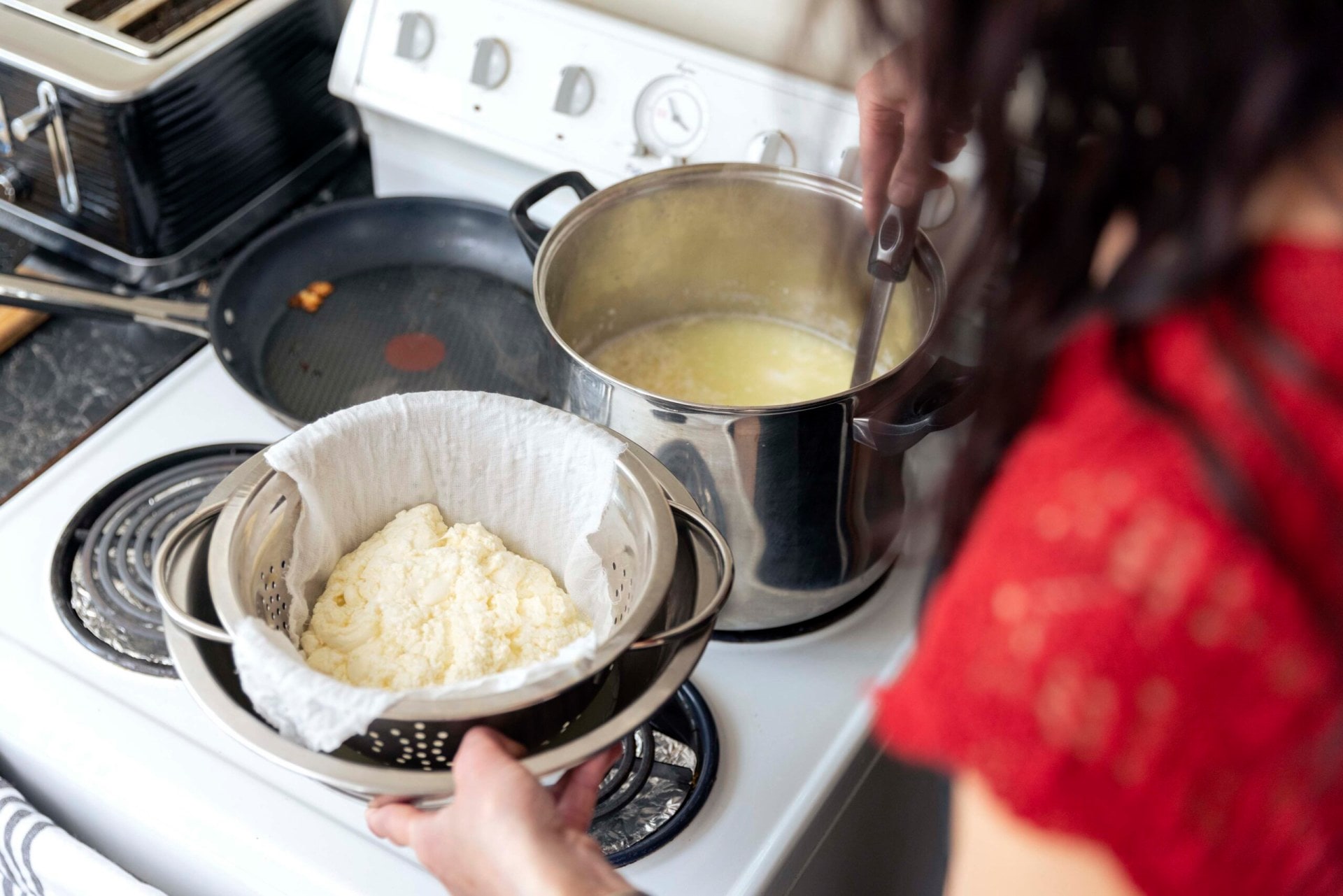 Alexis Murti looking over a pot making ricotta cheese