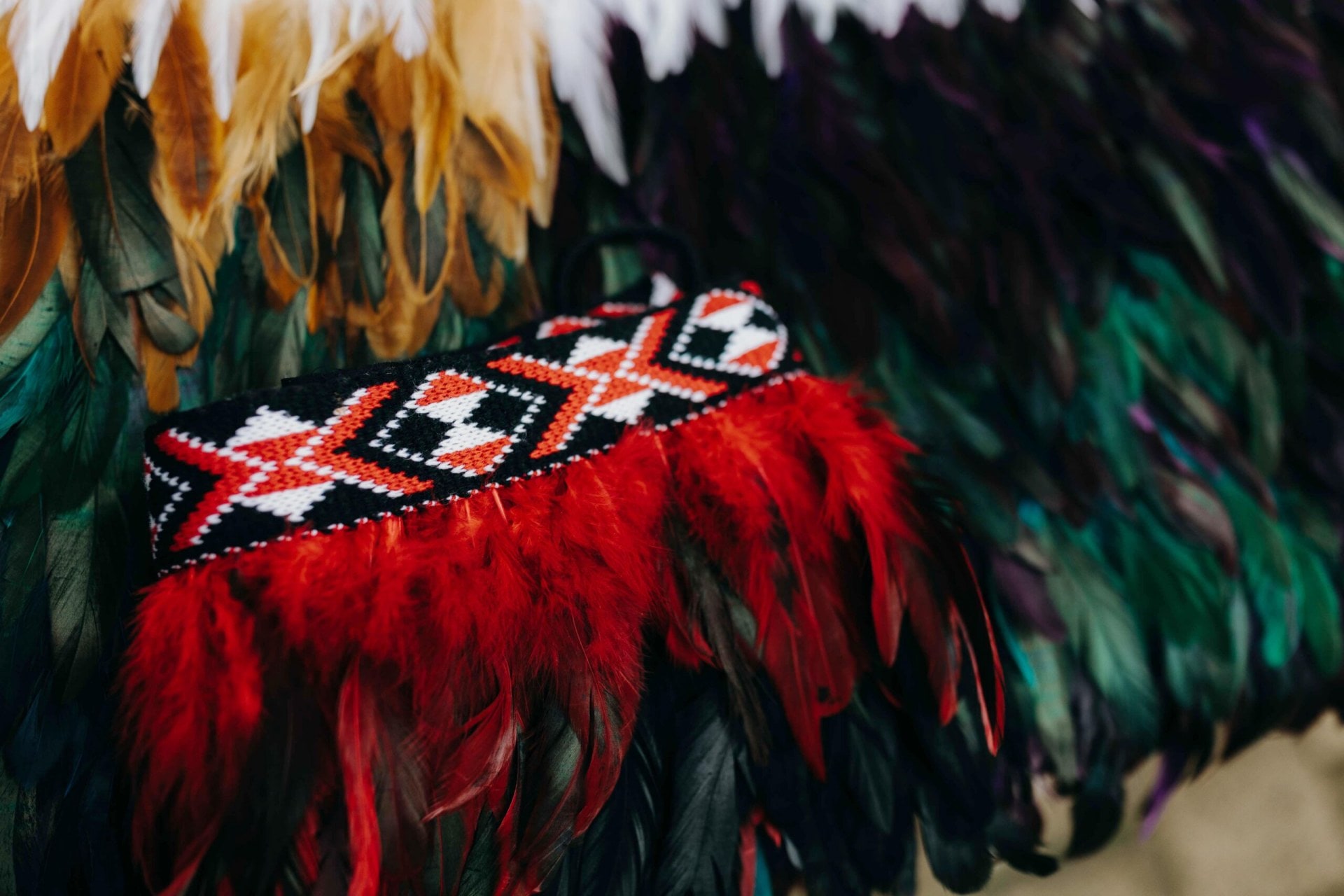 Green, brown and red Kids Korowai cloaks laid out