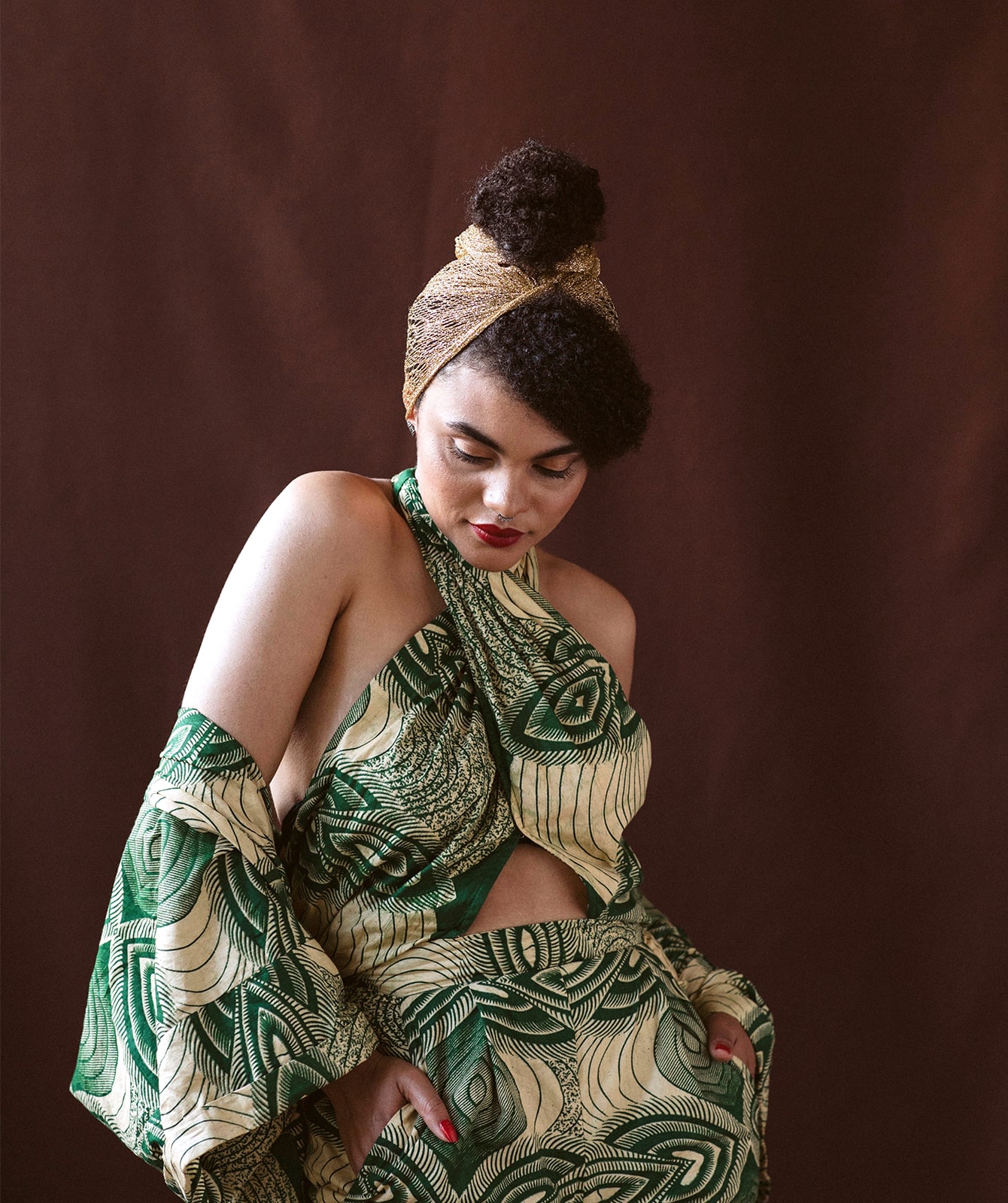 Estère Dalton wearing green and yellow patterned dress and matching headband