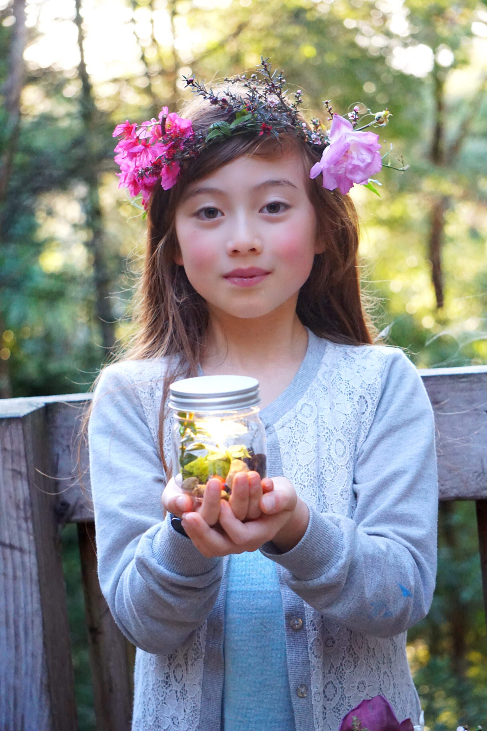 Little girl wearing flower crown holding a fairy lantern 