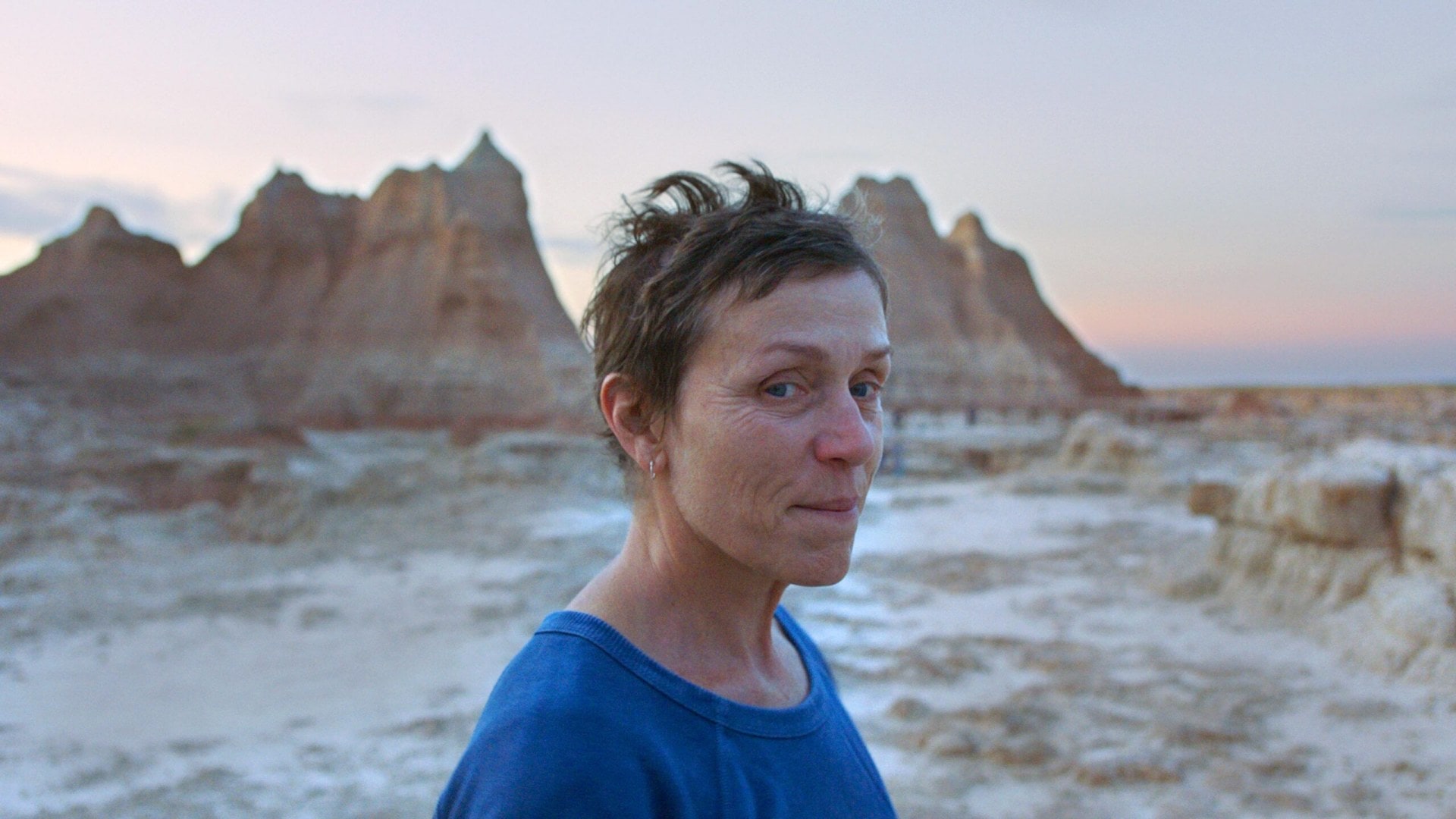 Frances McDormand standing on the beach in Nomadland