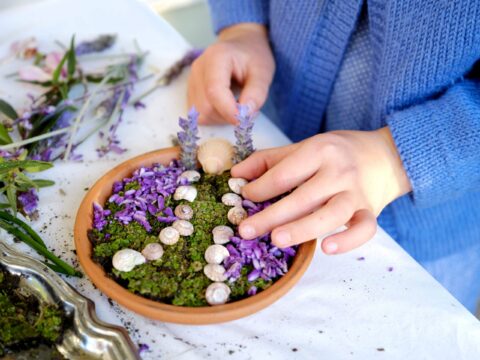 Child making miniature garden in little pot