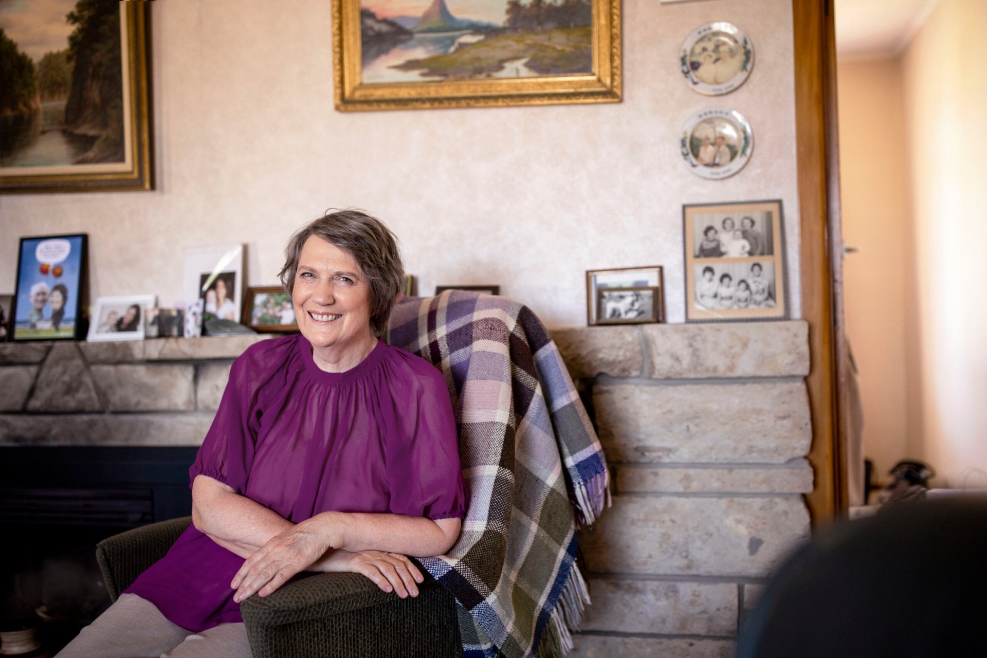 Helen Clark sitting in living room wearing purple top