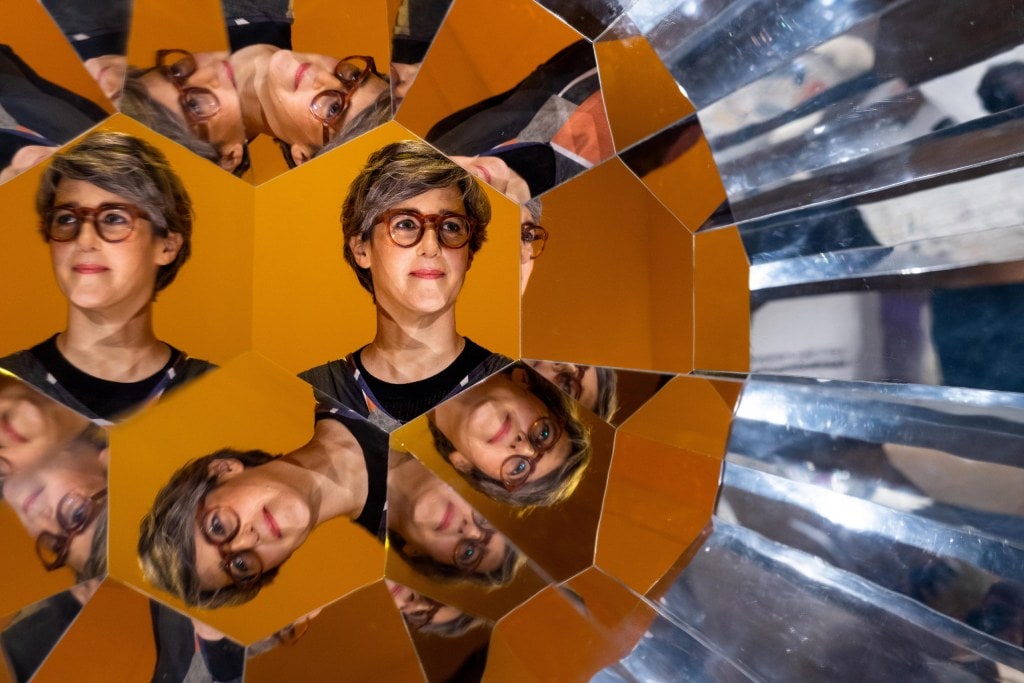 Kaleidoscope reflections of Lizzie Bisley wearing glasses and a black top