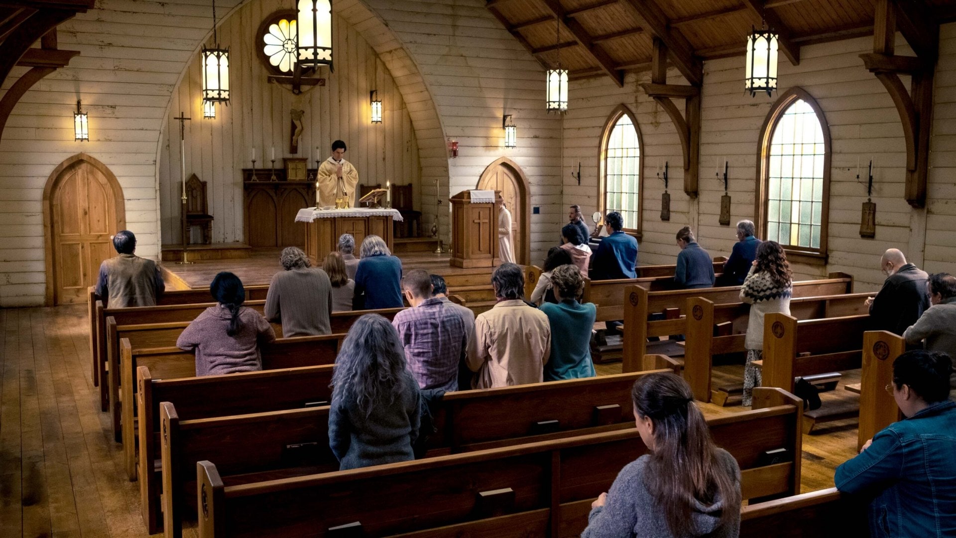 A church and patrons sitting in the pews in Midnight Mass 2021