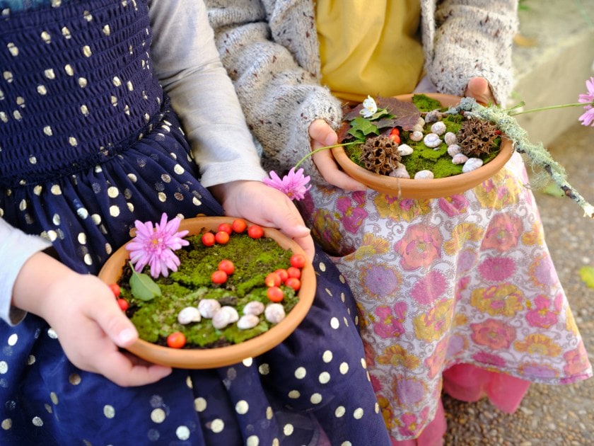 Children holding miniature gardens in a pot
