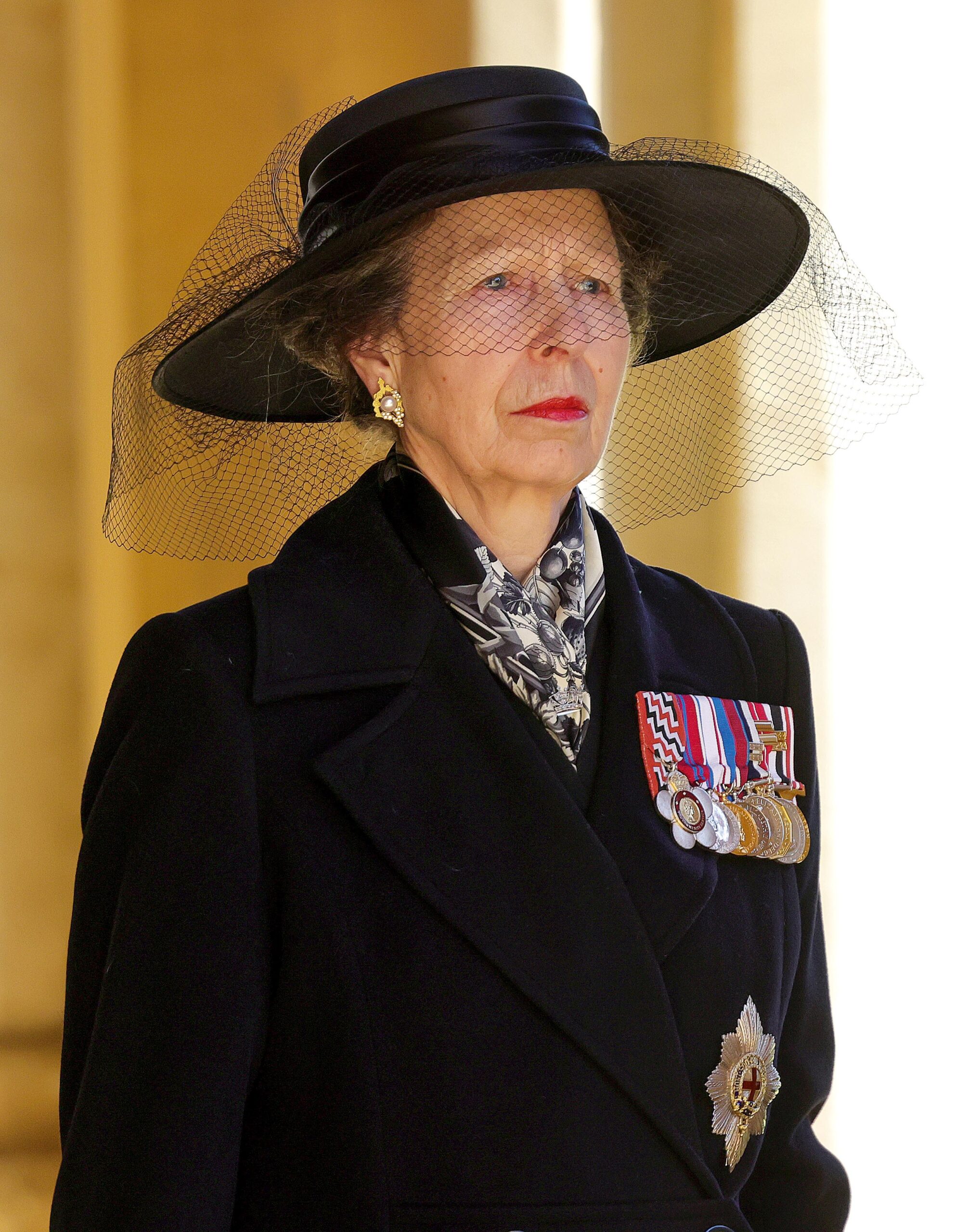 Princess Anne at Prince Philip's funeral. She's wearing a black coat and hat with military medals pinned to chest