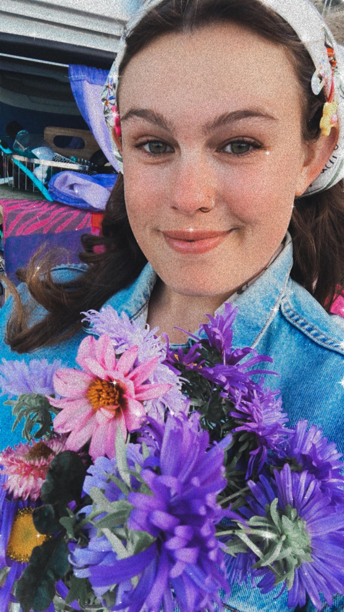 Selfie by Jess Thompson Carr wearing a head scarf, colourful pins and holding a bouquet of flowers