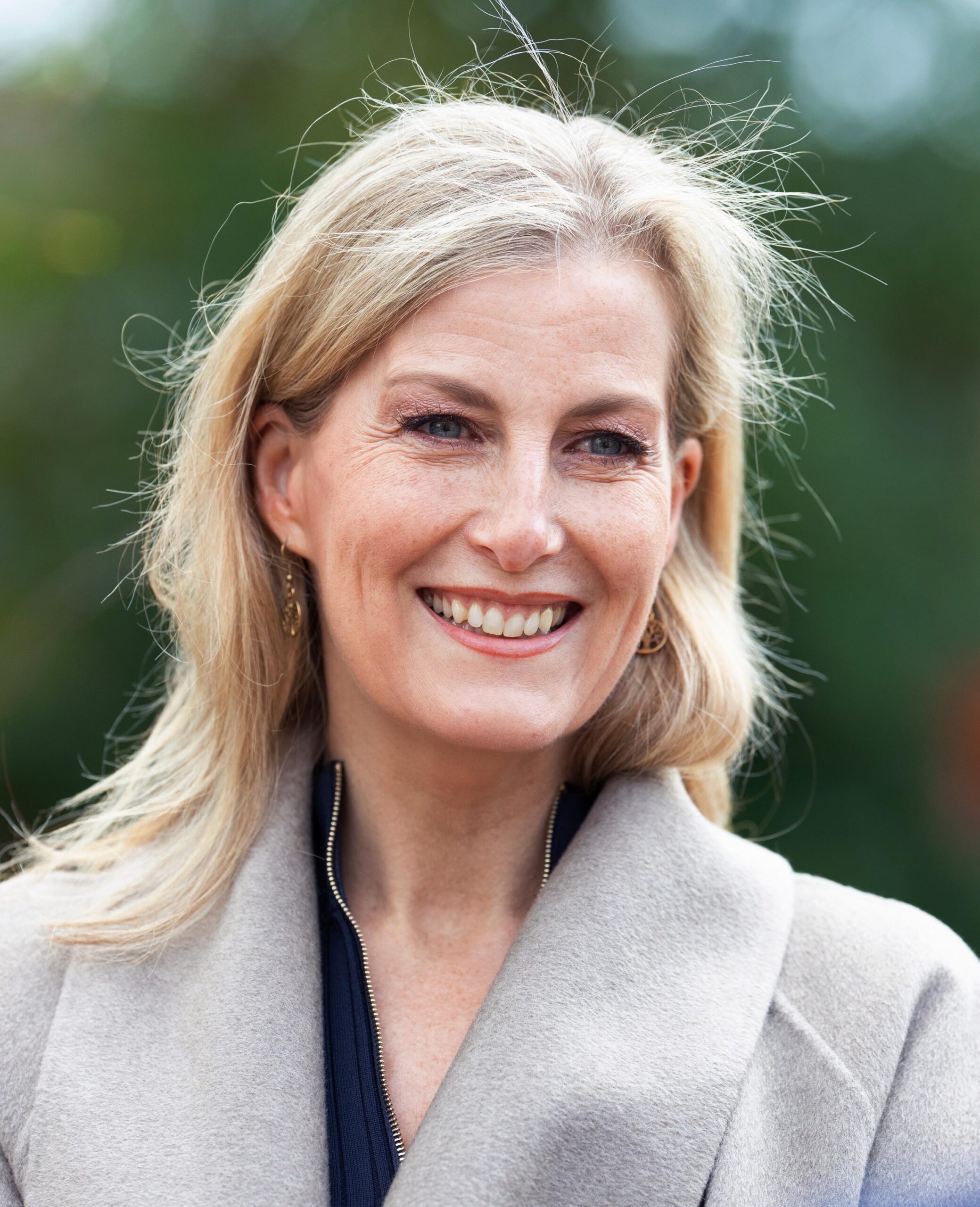 A head shot of Sophie, Countess of Wessex smiling and wearing a grey coat