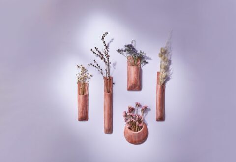 Terracotta wall vases hanging on purple wall