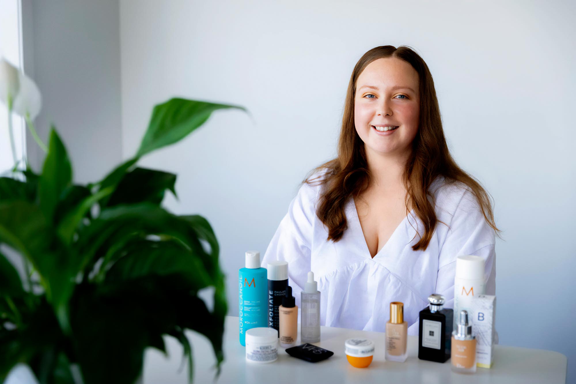 Anastasia Donnachaich sitting at a table with her skincare in front of her