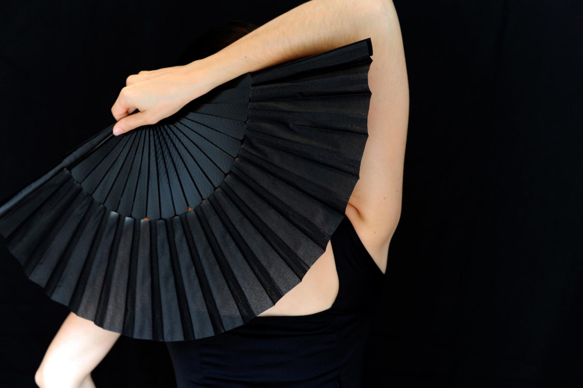 woman in black holding a black fan