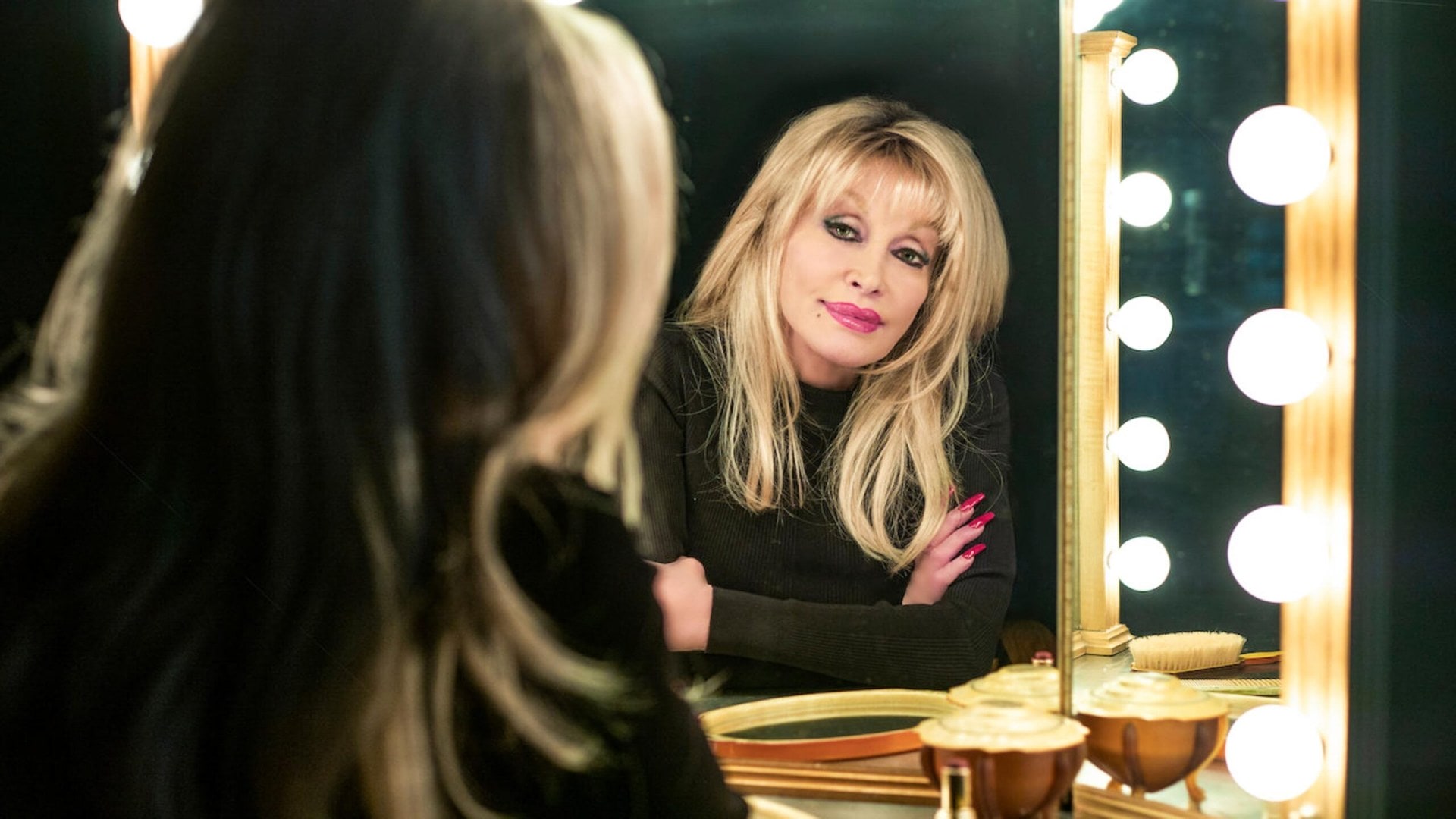 Dolly Parton look in a mirror at the camera