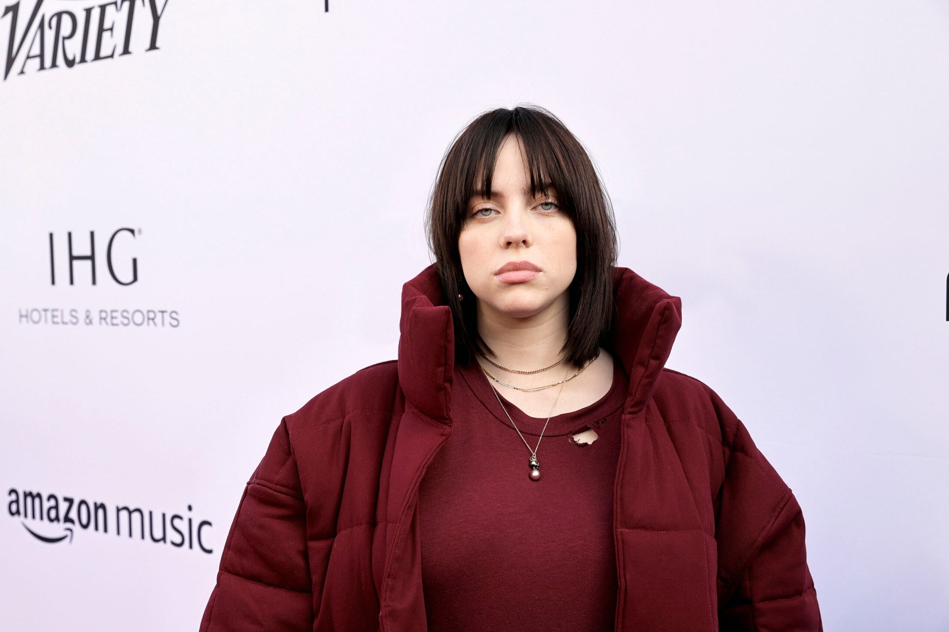 Billie Eilish in a burgundy jumper and jacket