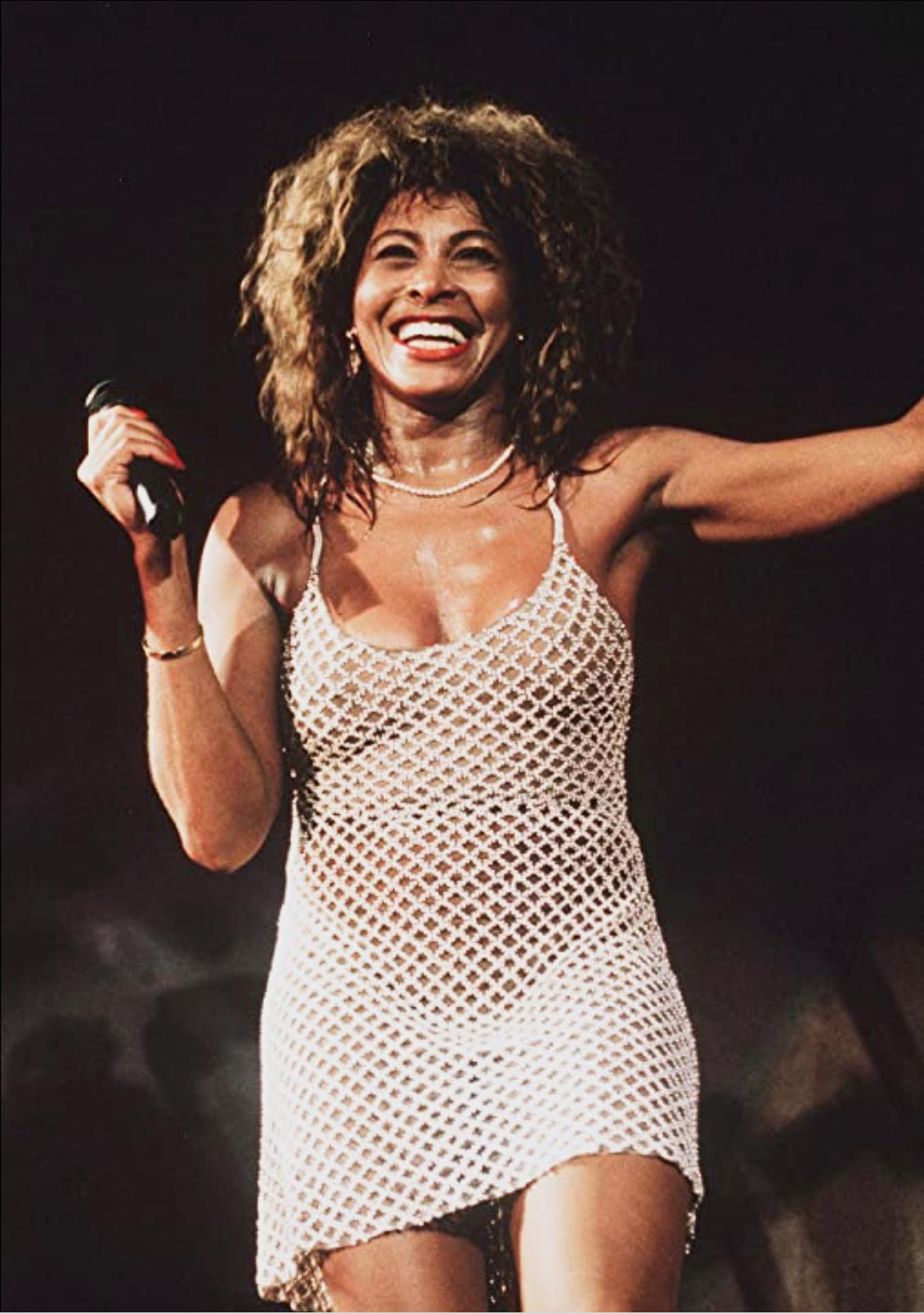 Tina Turner on stage in a cut out mini dress
