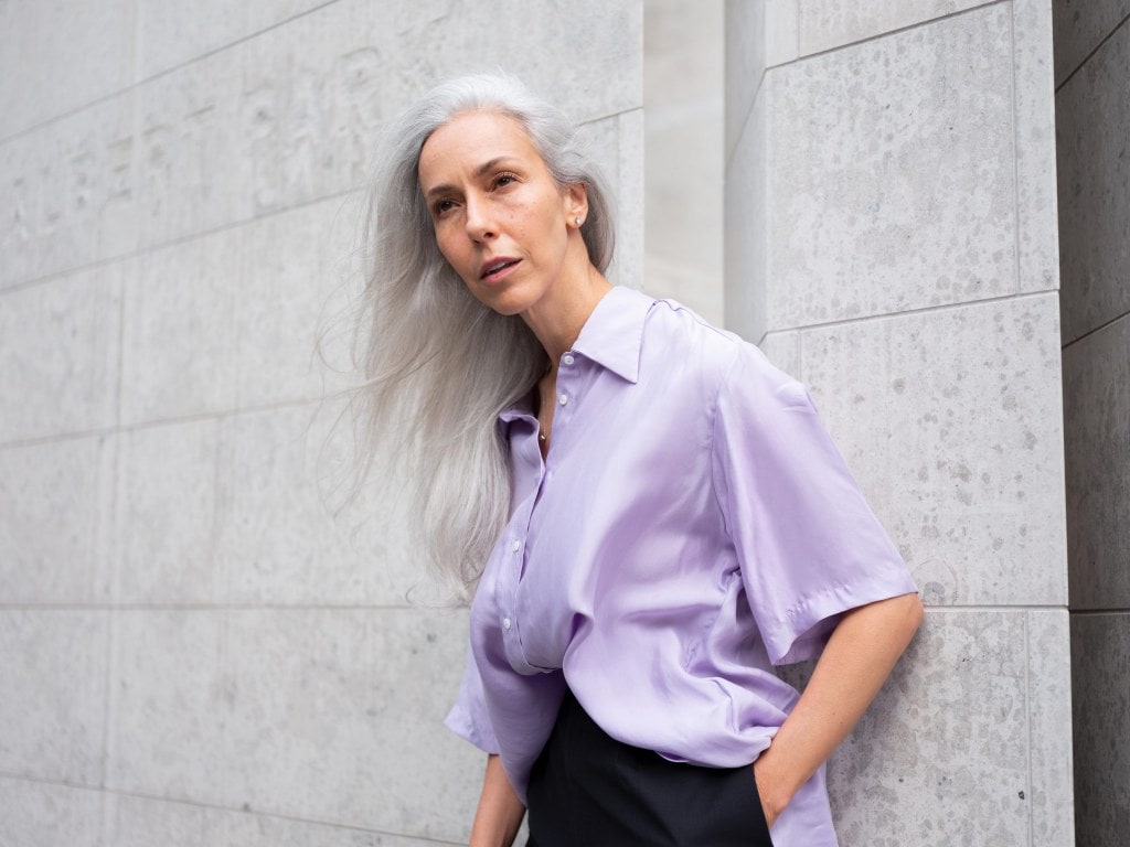 woman with white hair in a lilac shirt