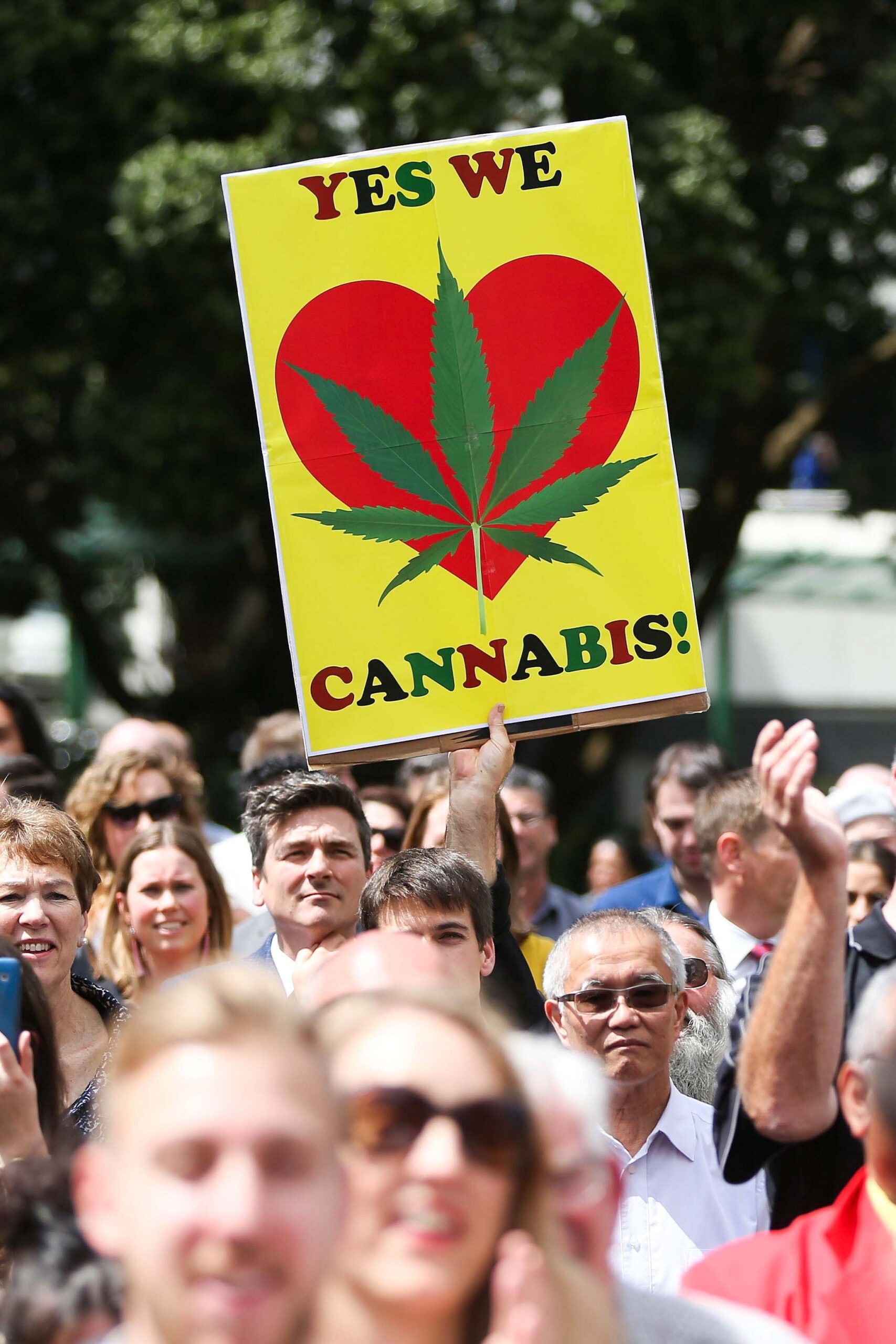 Protesters at a rally holding a pro-cannabis sign.