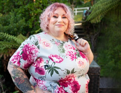 a woman with short pink hair in a floral dress