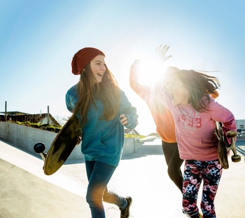 Three girls running in skatepark