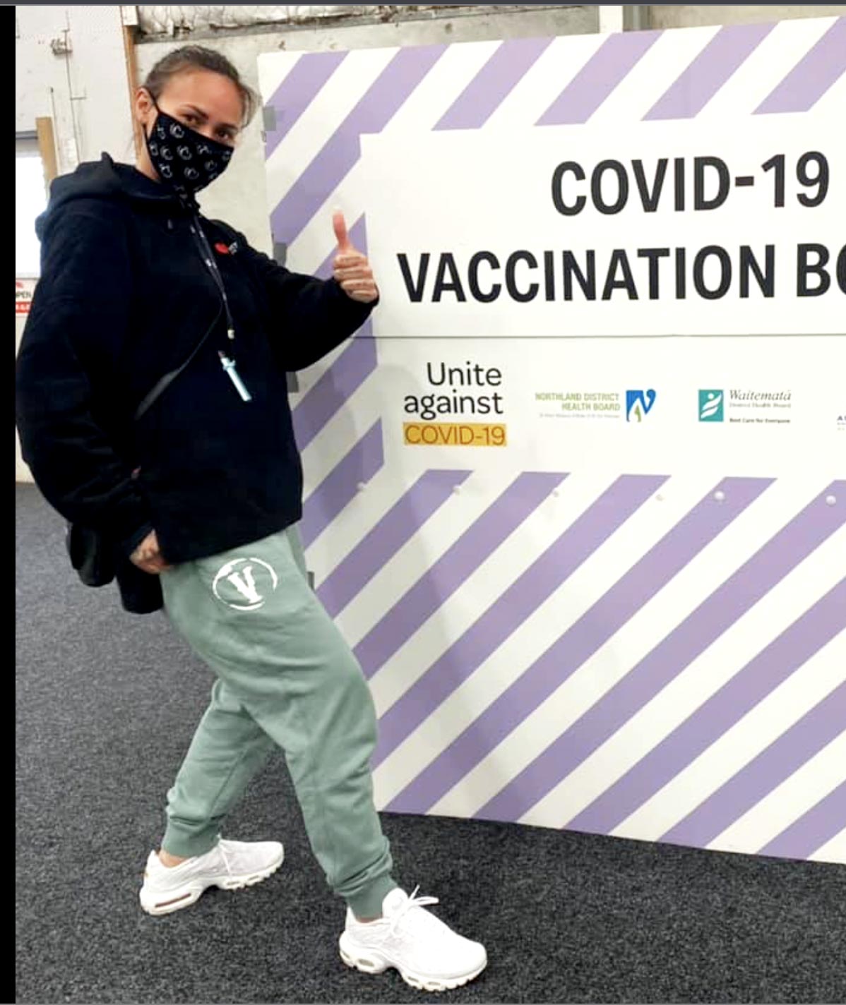 Nix Adams standing in front of Covid Vaccine Branded Sign
