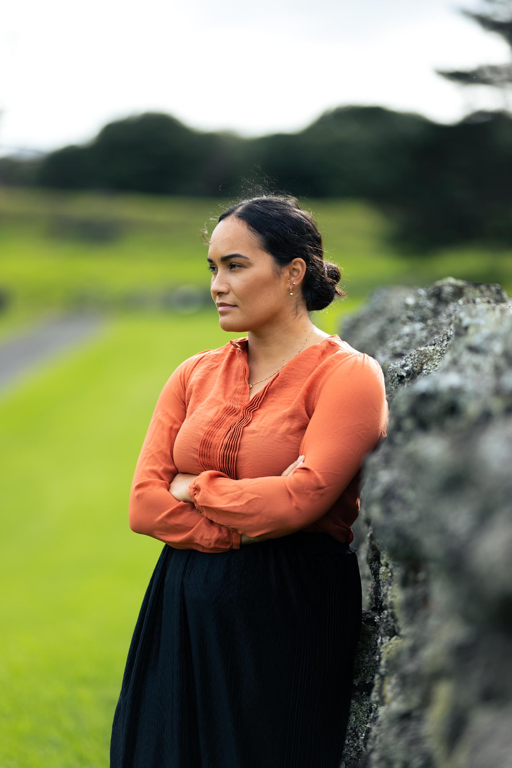 Pania Newton in an orange top at Ihumātao