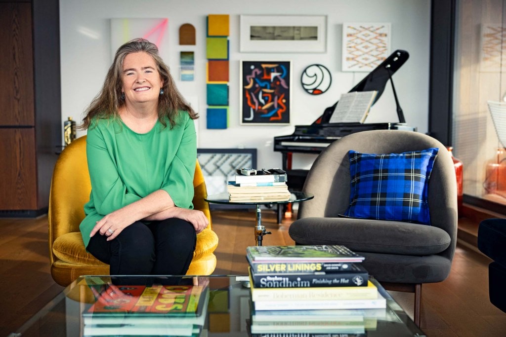 Anne O'Brien sitting on a chair with a pile of books