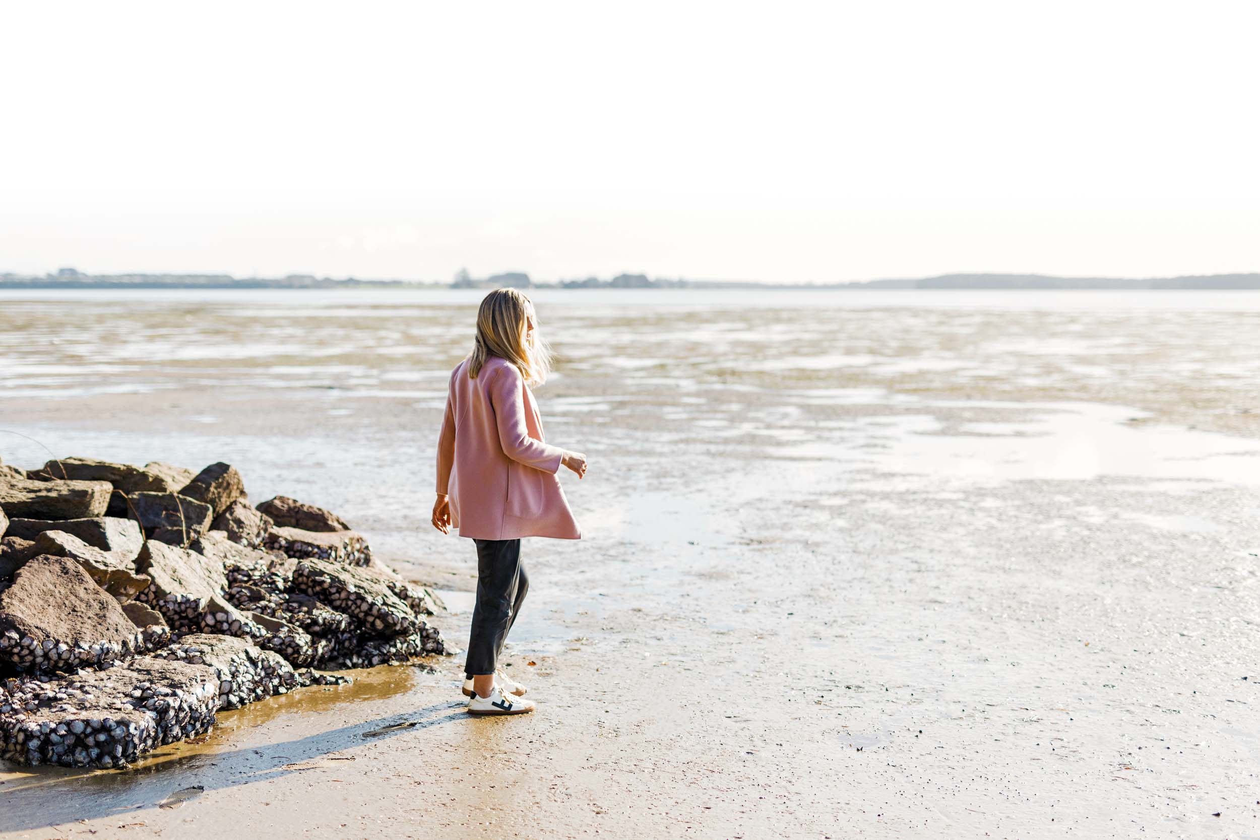 Sharon Hunter on a rocky beach walking into the water