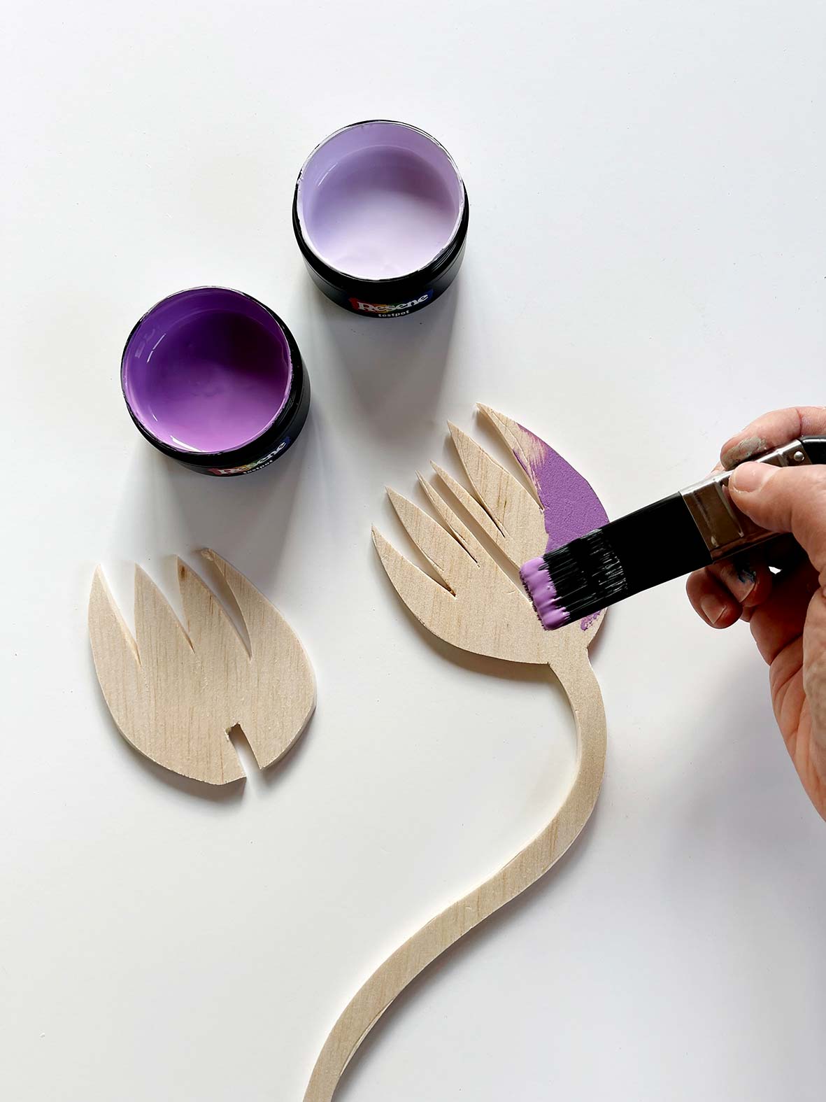 wooden flower cutouts being painted purple