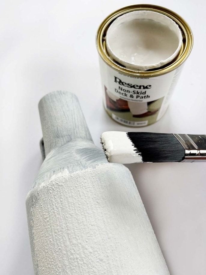 white paint being applied to a vase