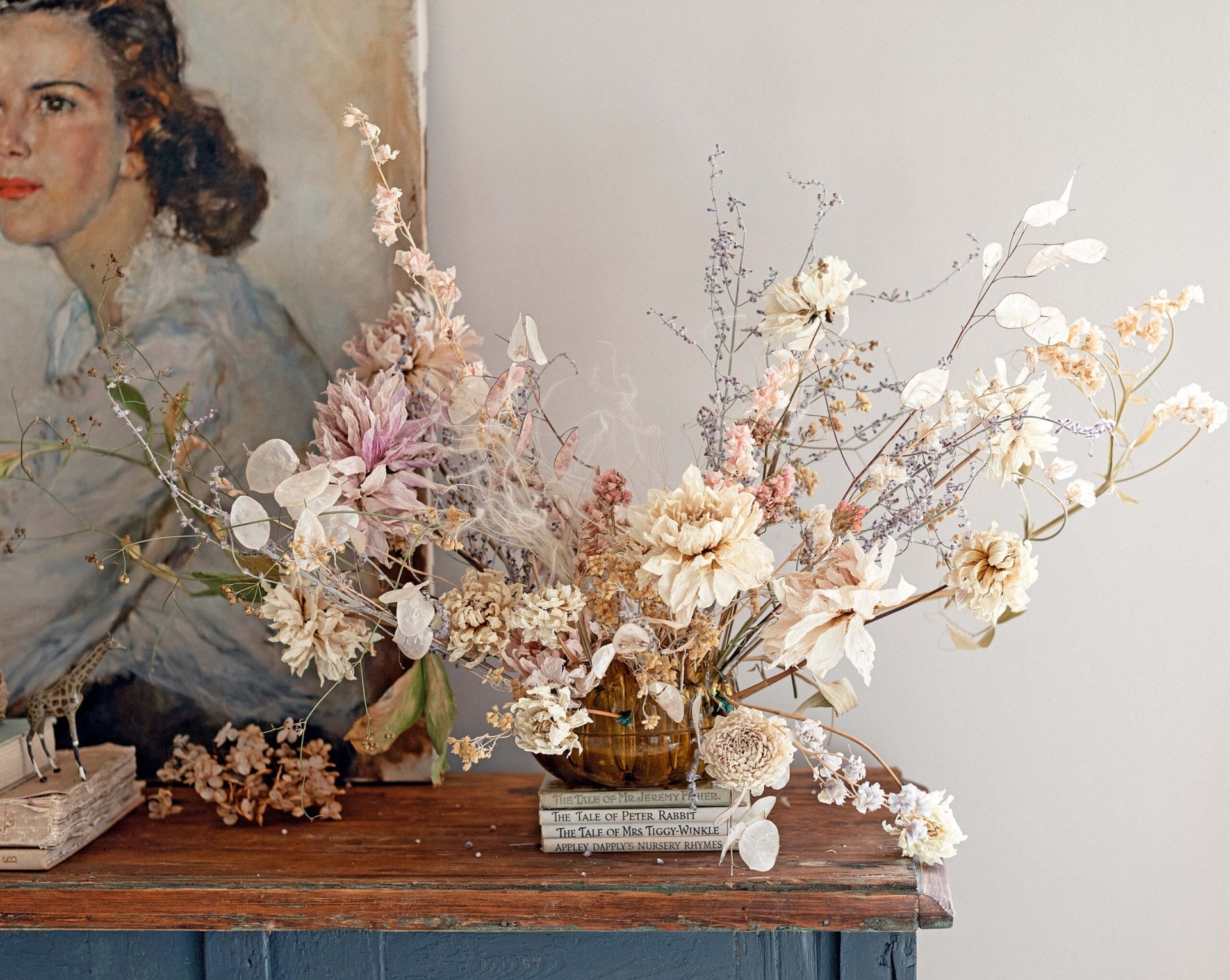 A flower arrangement of pink and white flowers set on a rustic brown table by The Flower Hunter