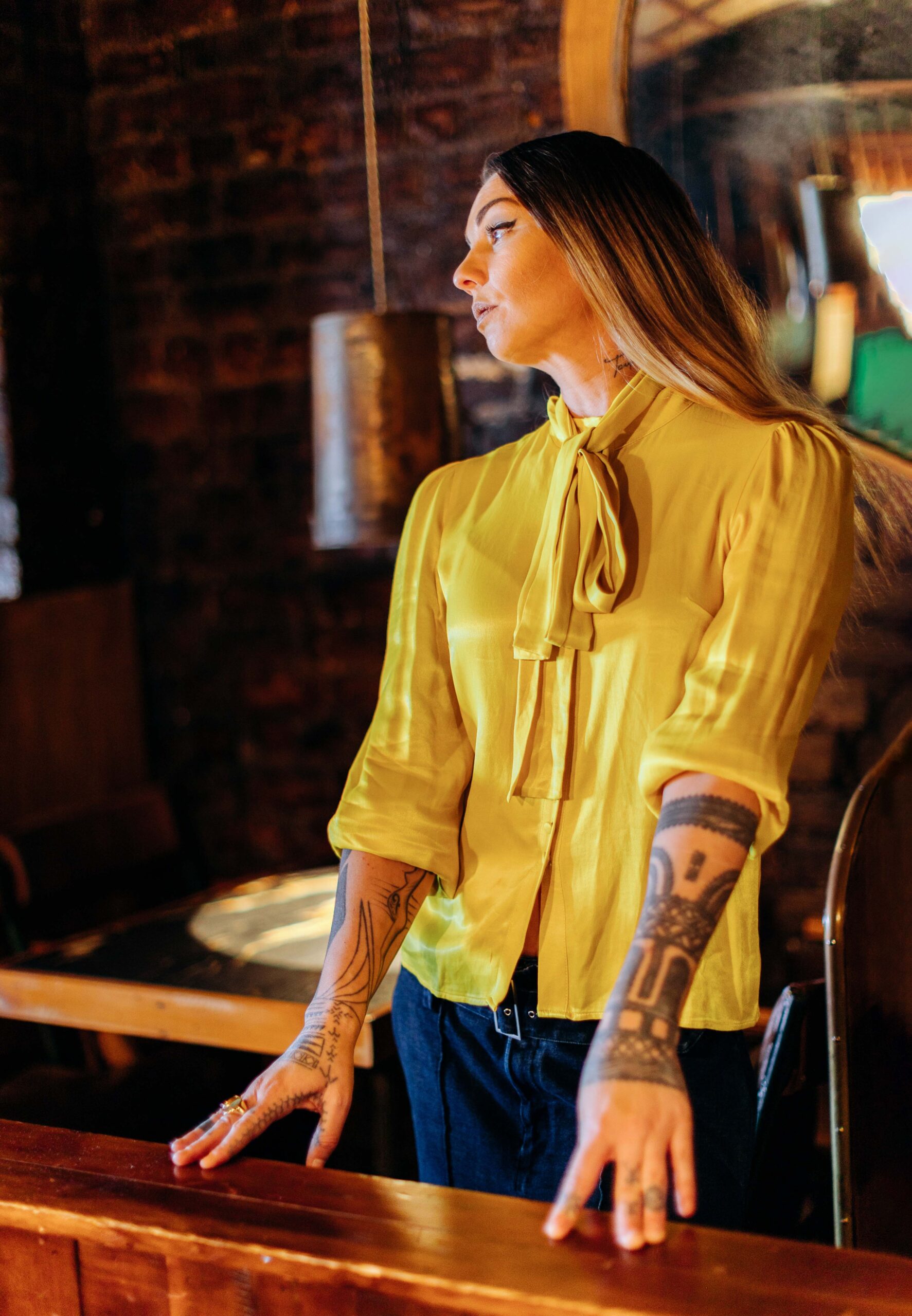 Hollie Smith in a yellow top with her head tilting away to the side