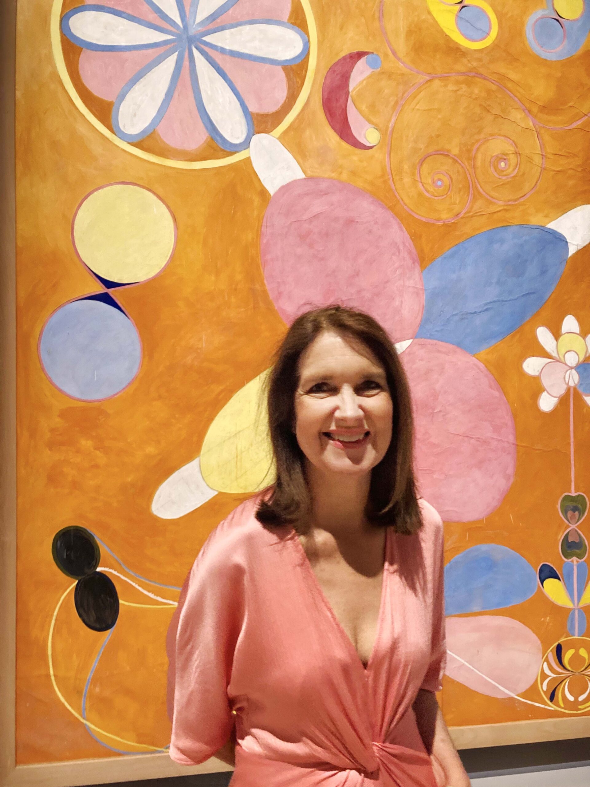 Sue Cramer standing in front of one of Hilma af Klint's paintings