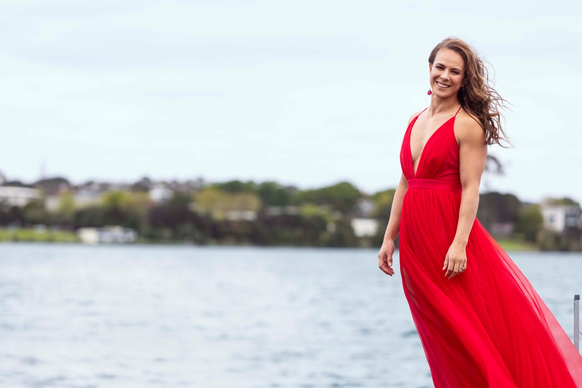 Lisa Carrington in a red dress beside a lake