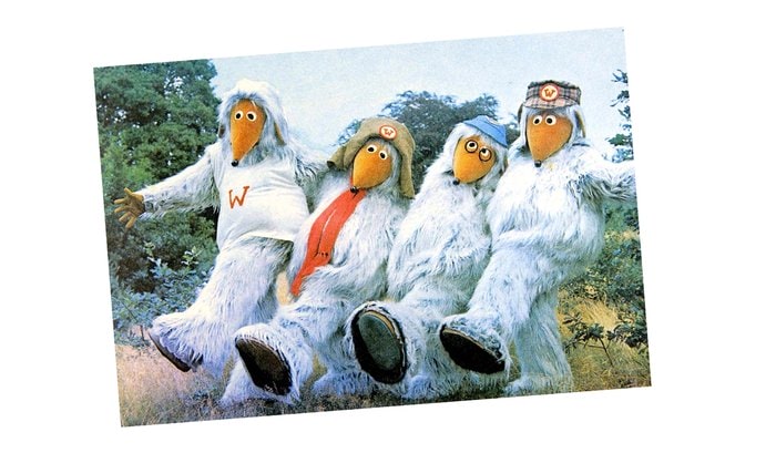 The Wombles standing in a line kicking up their feet