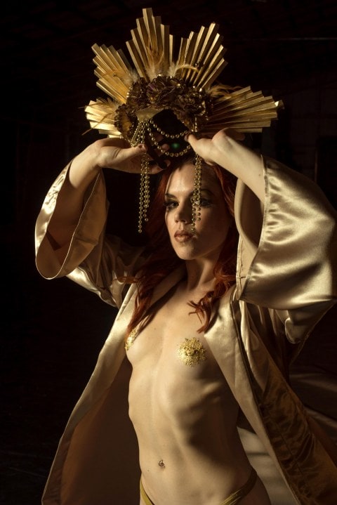 Hannah Tasker-Poland in a gold robe and paint over her nipples