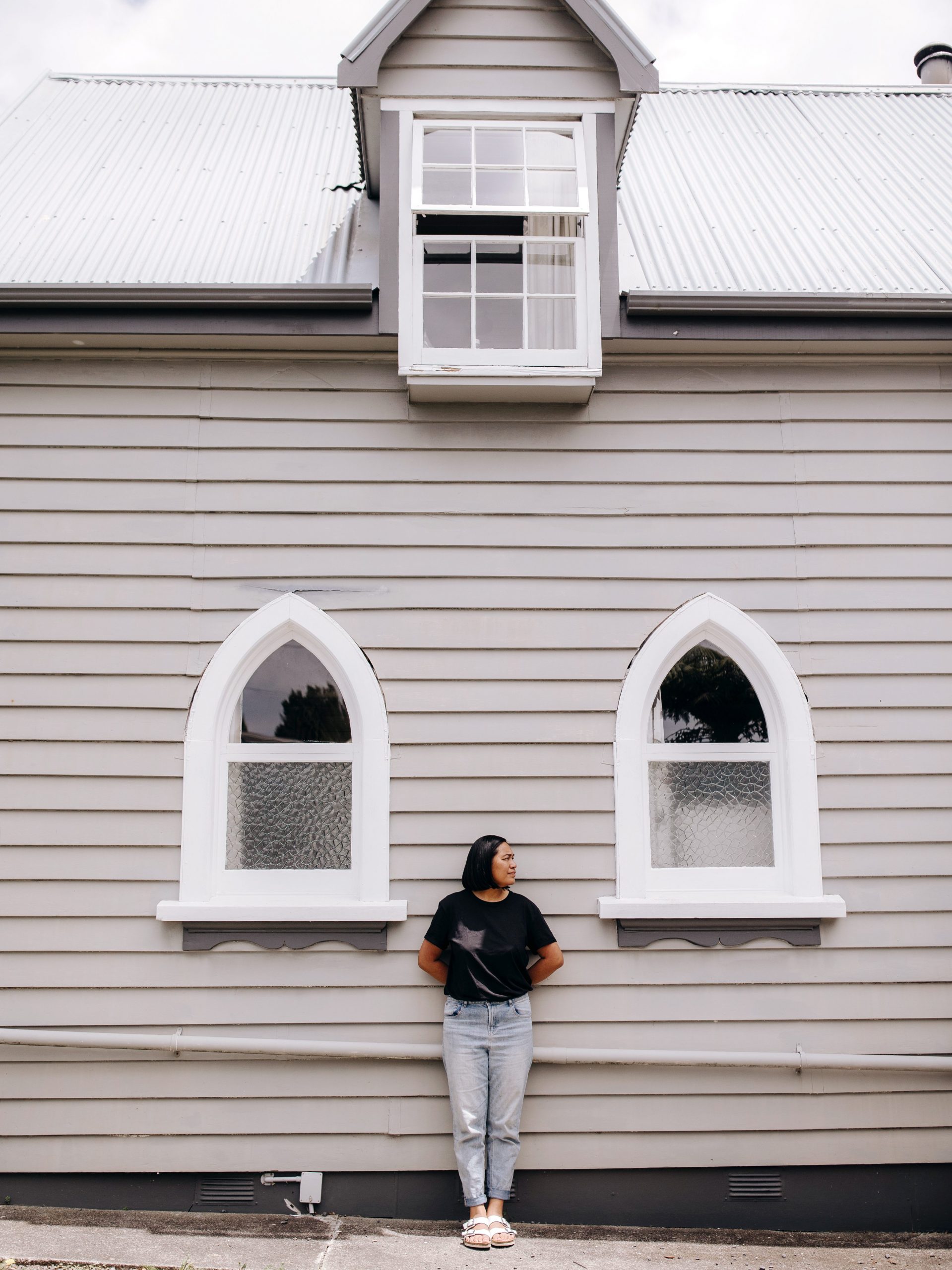 Cora-Allan stands in front of her house