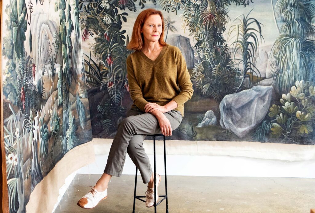 Kerrie Hughes sitting in front of her painted fabric