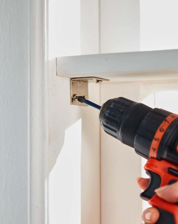 A corner of a window frame being drilled using driller