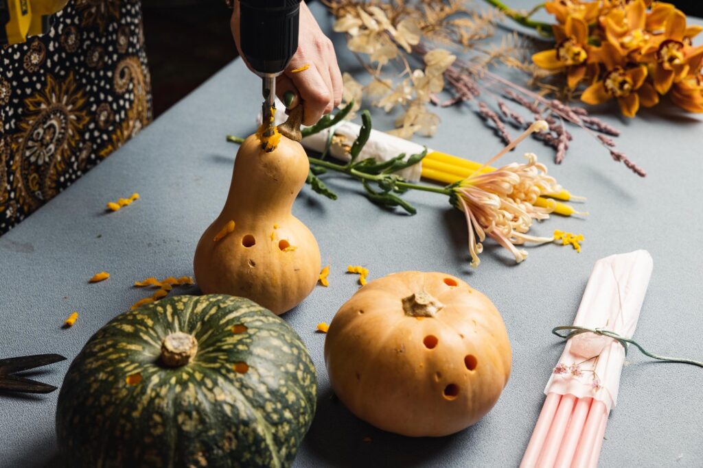 A drill drilling holes in a pumpkin