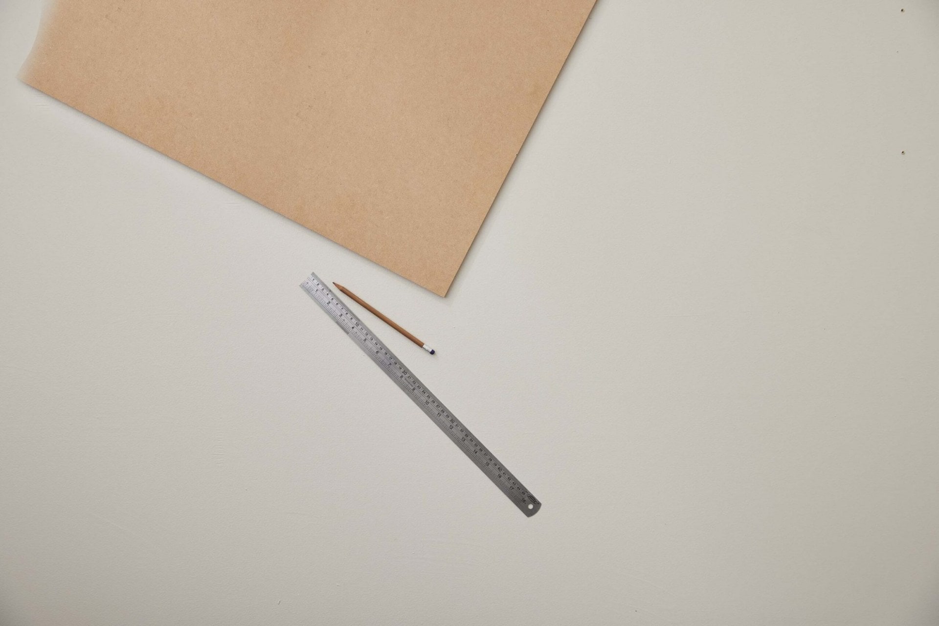 A piece of MDF board with a ruler and a pencil next to it