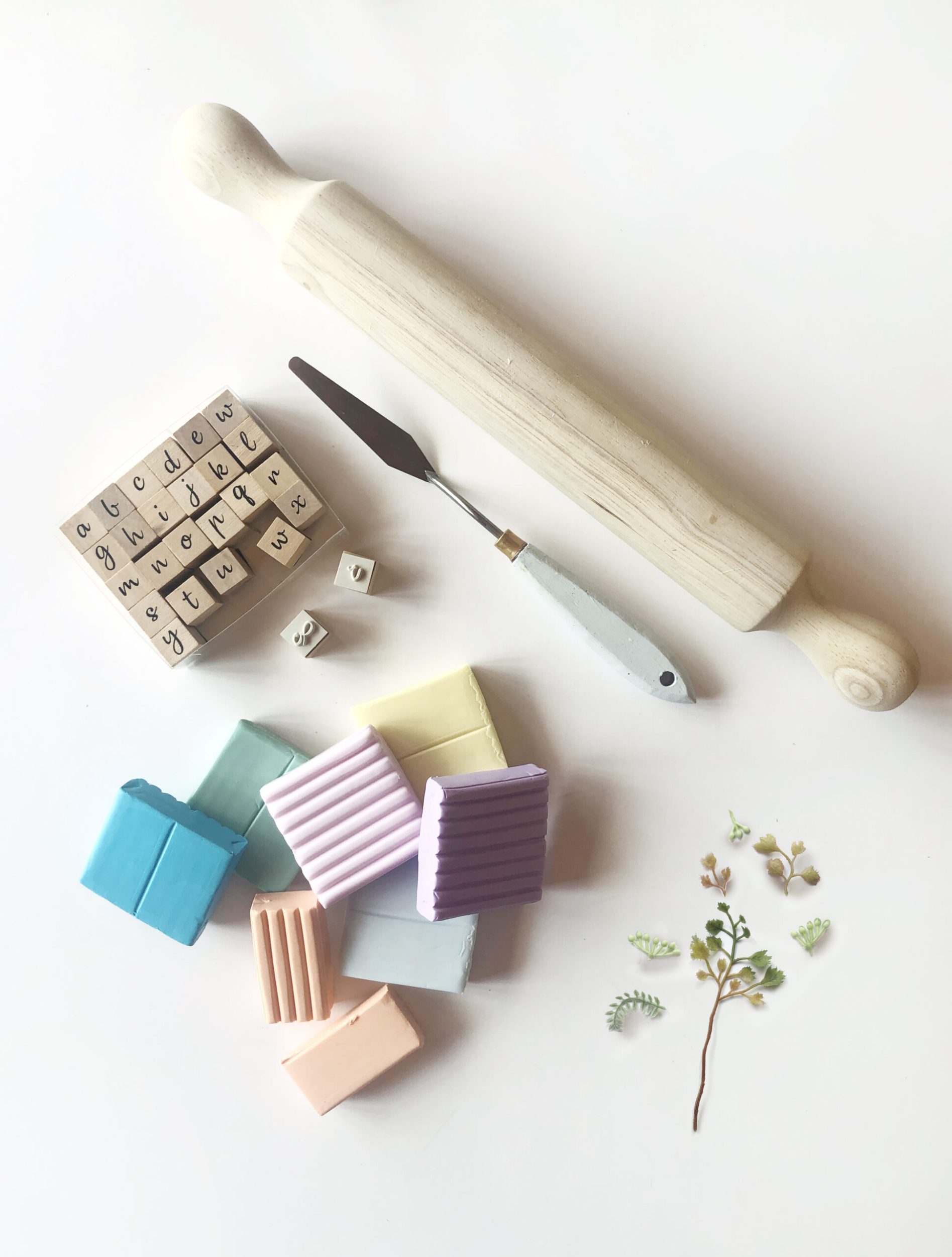 Flay lay of baking clay, alphabet stamps and a rolling pin