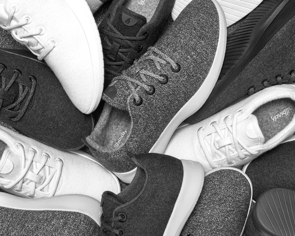 A black and white photo of a pile Allbirds Wool Runners
