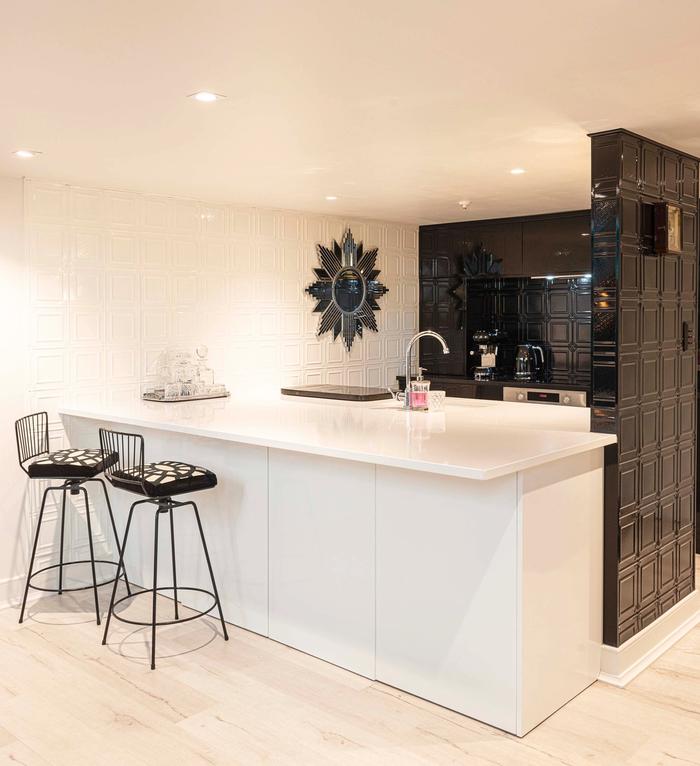 A black and white kitchen with hammered panels and bar stools