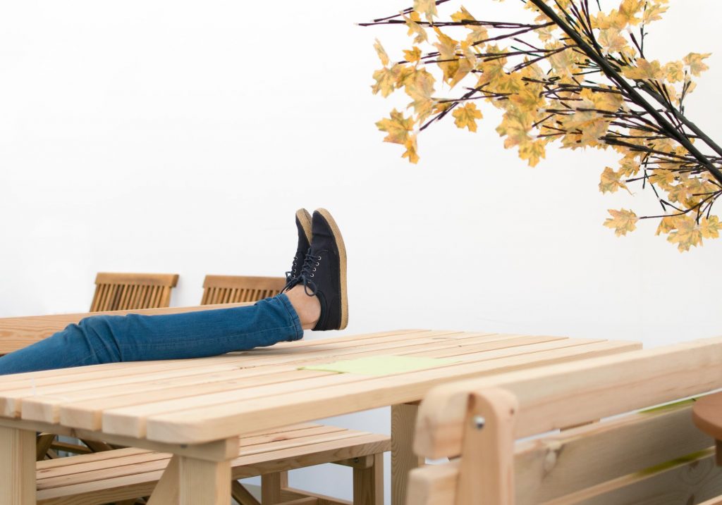 Legs in denim resting on a wooden table