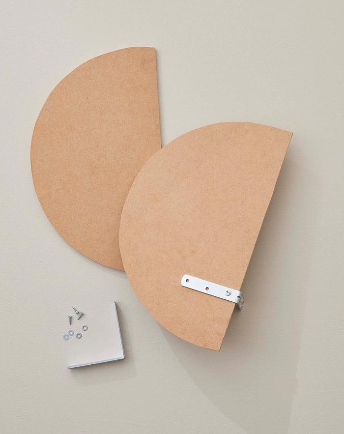 Two oval shapes cut out of an MDF board with brackets attached at the back