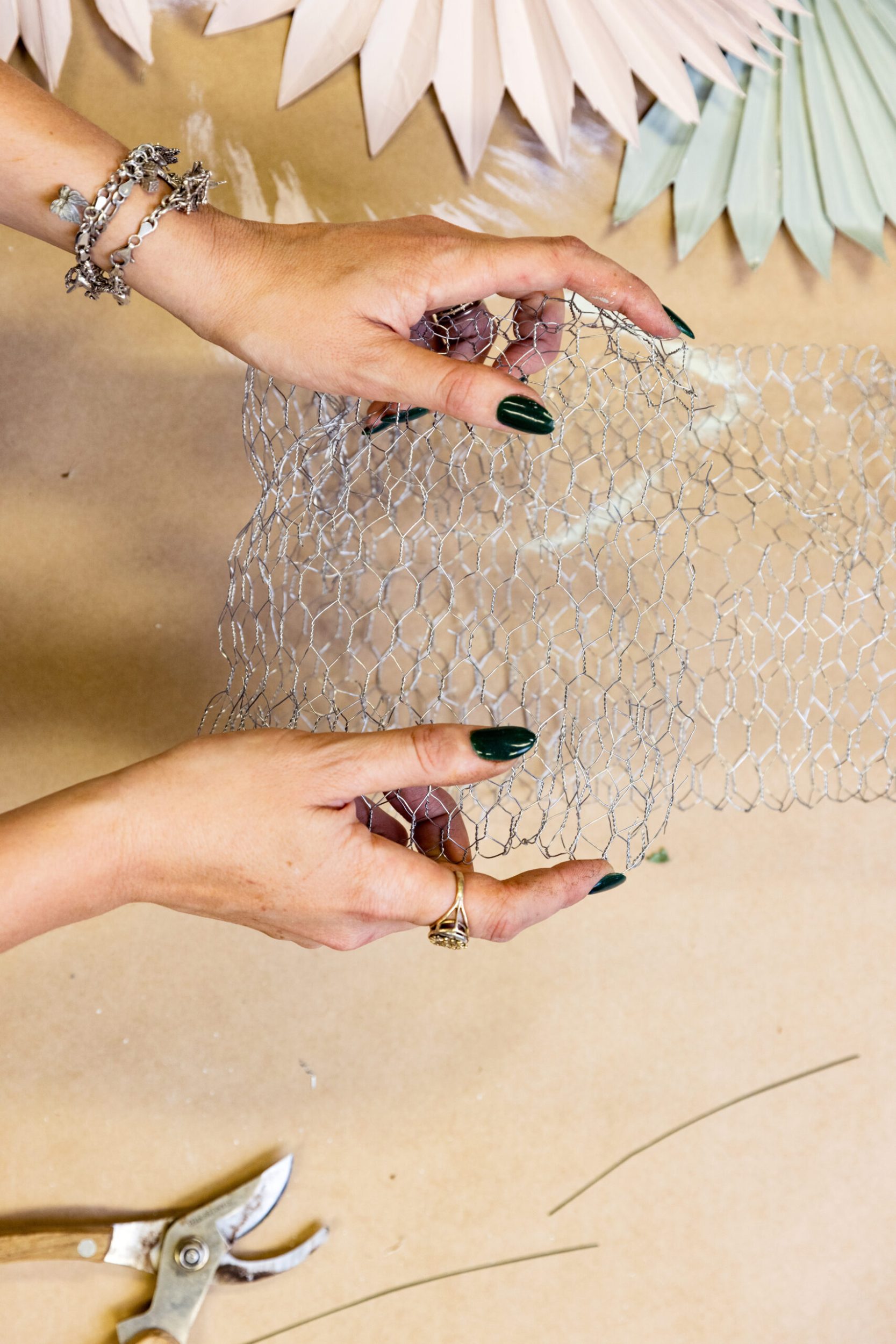 Hands holding metallic chicken wire 