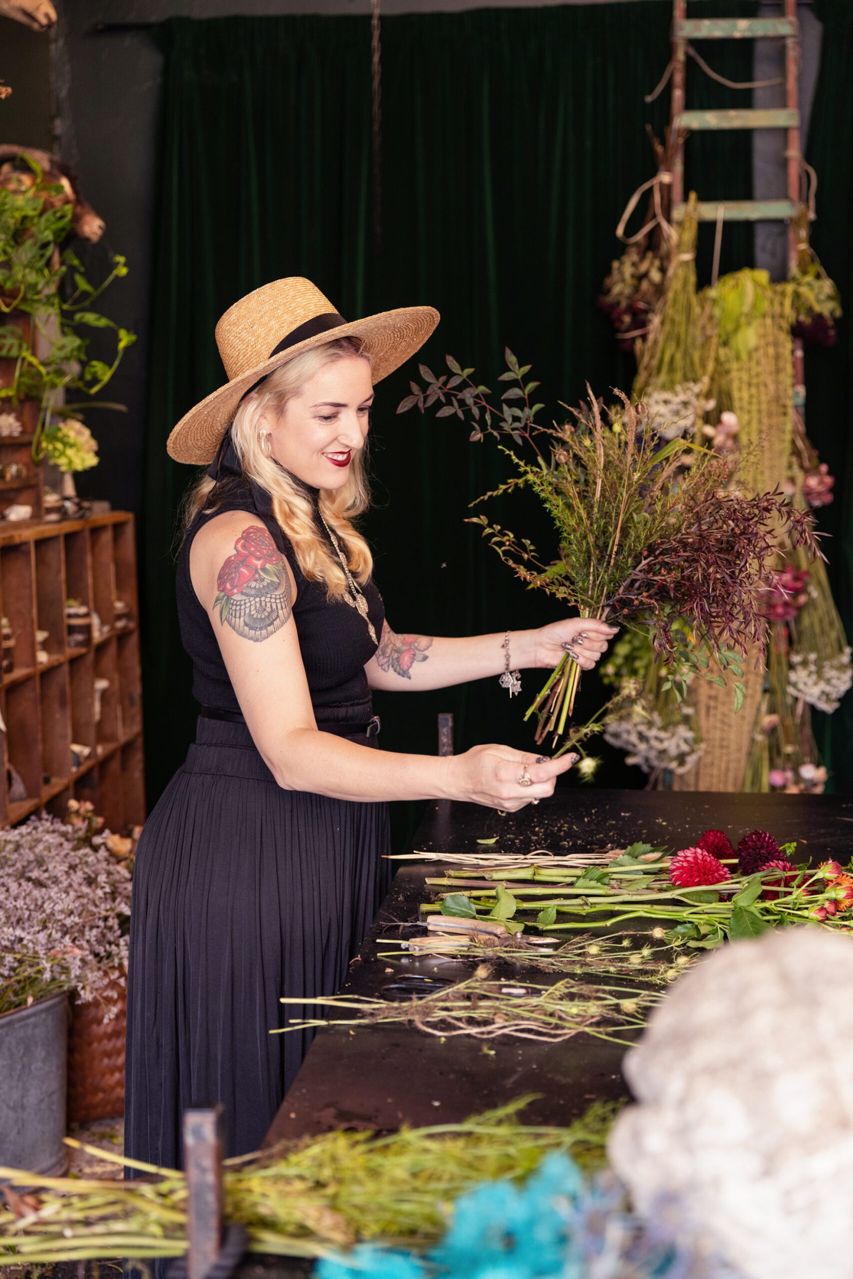 Georgie Malyon holding flowers wearing black dress