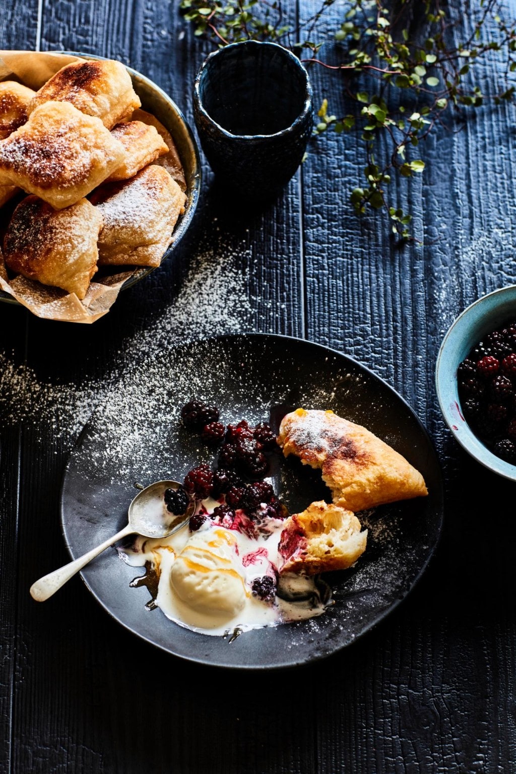 Parāoa parai fried bread with vanilla ice cream and berries on a black bowl