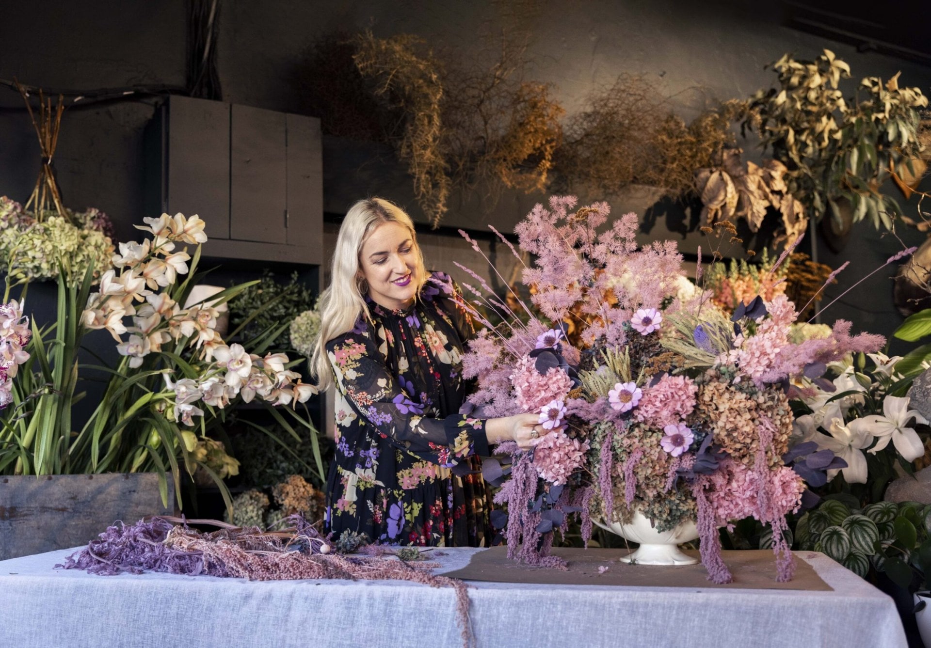 Georgie Malyon placing short purple fried flowers into a Beswick flower urn