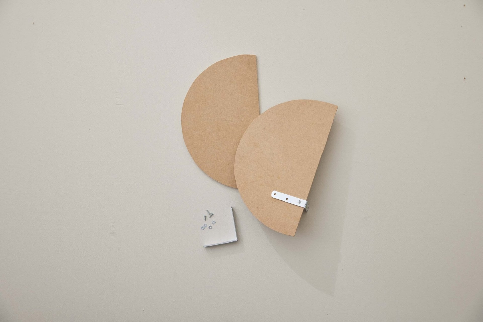 Two oval shapes cut out of an MDF board with brackets attached at the back